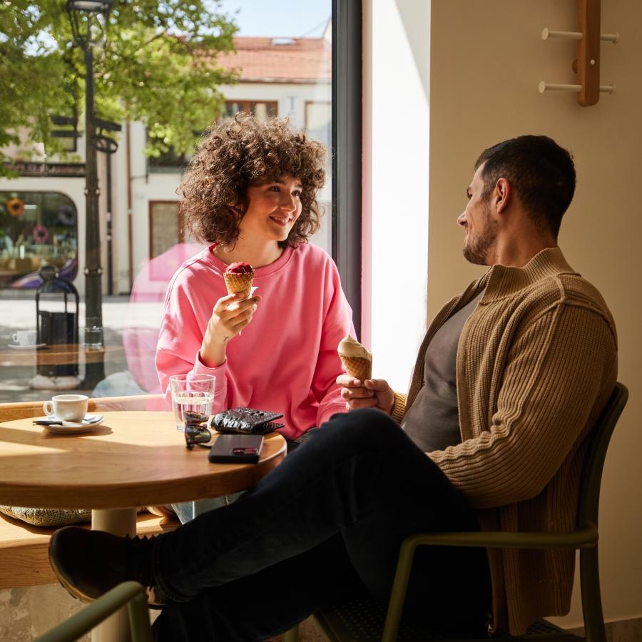 a man and woman sitting at a table eating food